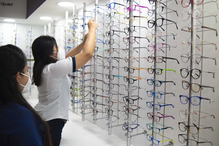 Fotografía de óptica visualiza clínica privada con nuestras asesoras colocando los aros en el mostrador