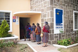 fotografía entrada a la clínica de Quetzaltenango, pacientes realizando cola para poder ingresar al área de recepción