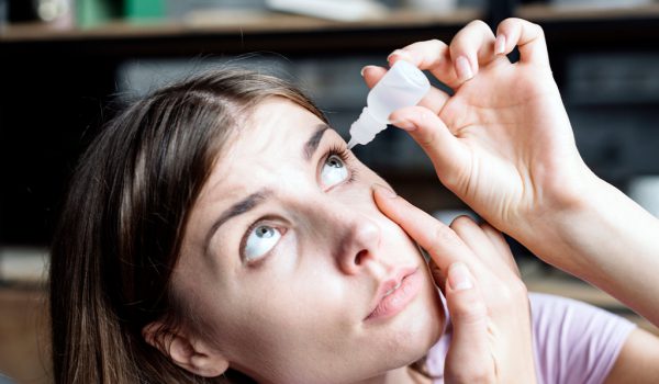 fotografía persona aplicándose gotas en los ojos